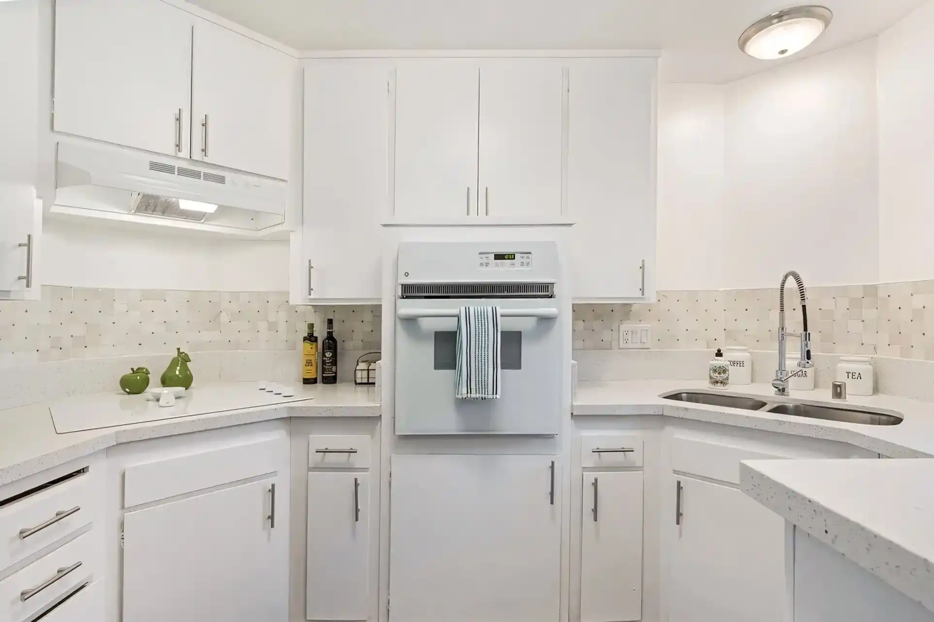 Armada Apartments renovated kitchen with white cabinetry and tile backsplash