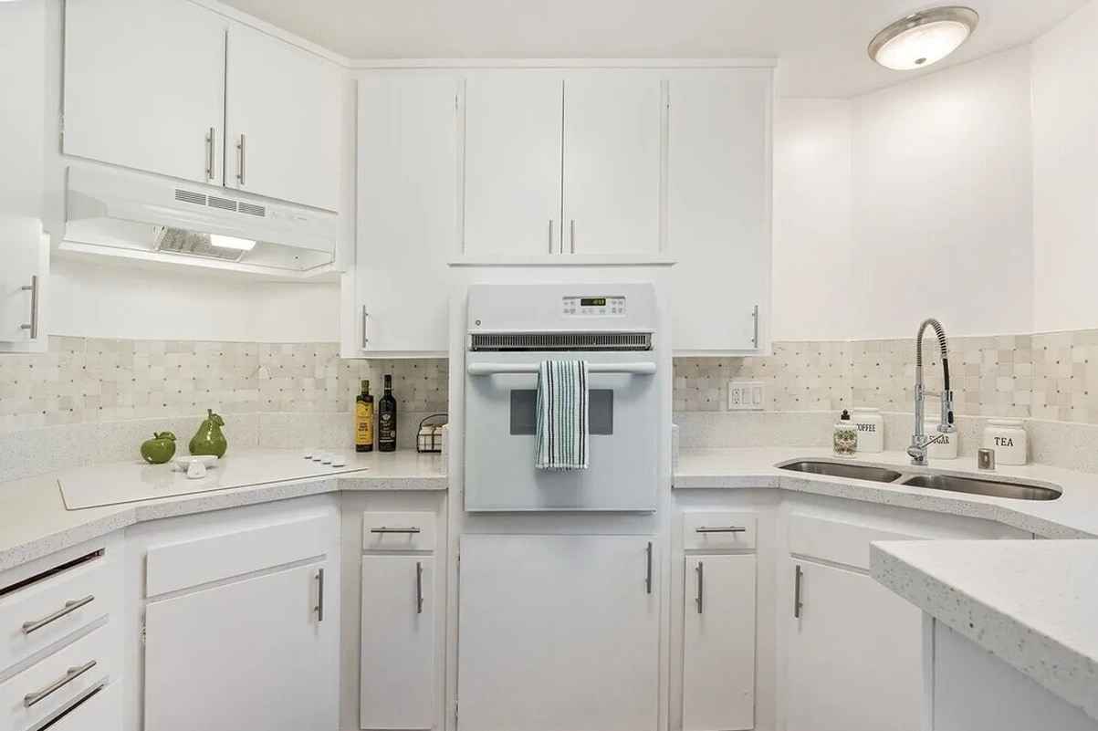 Armada Apartments renovated kitchen with white cabinetry and tile backsplash
